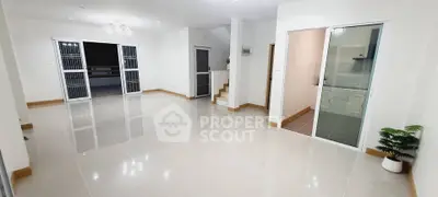 Spacious open-plan living area with modern tile flooring and large windows.