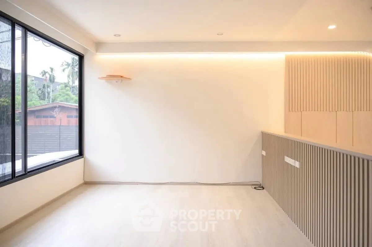 Modern minimalist living room with large window and wooden accents
