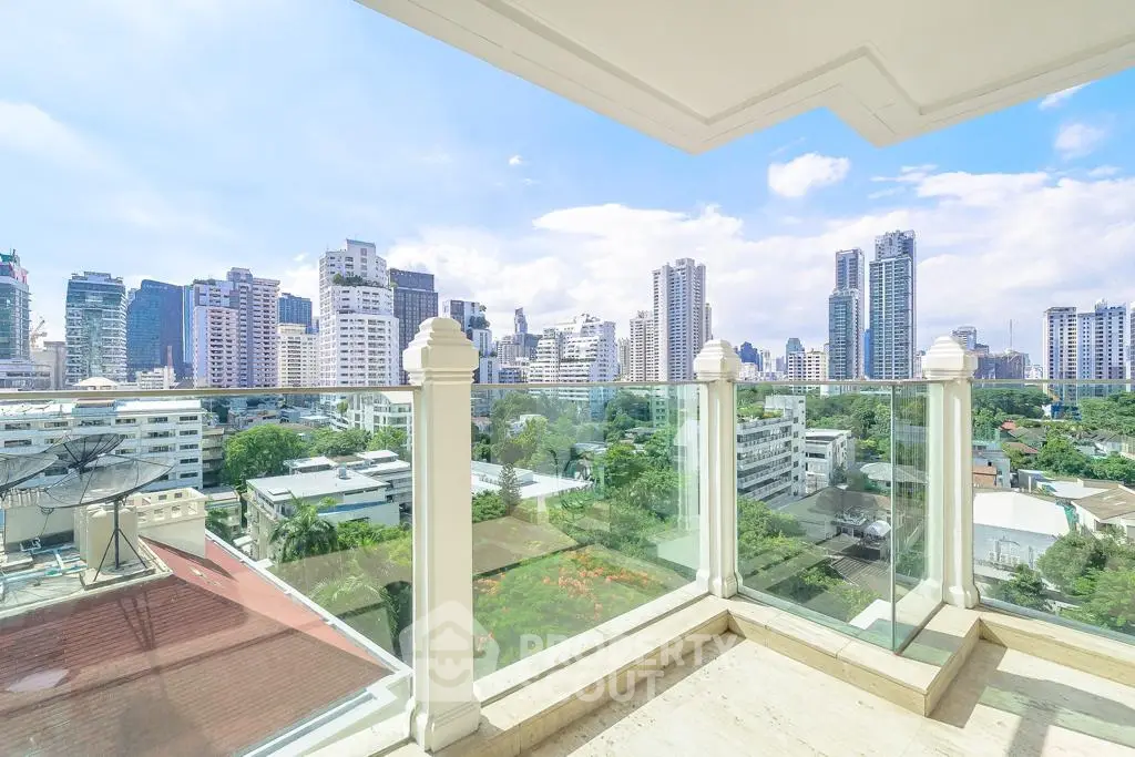 Stunning cityscape view from a modern glass balcony in a high-rise building.