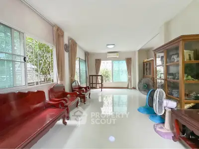 Spacious living room with elegant wooden furniture and large windows offering natural light.