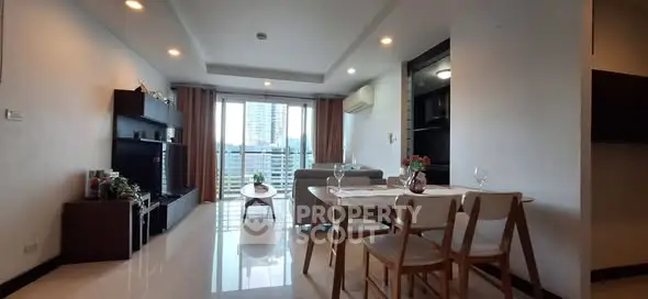 Modern living room with dining area and large windows offering city view.