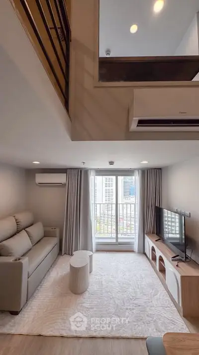 Modern living room with high ceiling and large window, featuring cozy sofa and sleek TV setup.