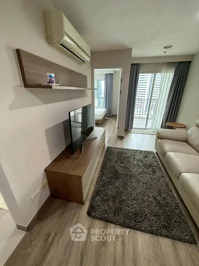 Modern living room with sleek furniture and balcony view in a stylish apartment.