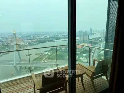 Stunning high-rise balcony view overlooking river and cityscape with modern bridge.