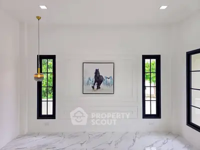 Elegant minimalist room with marble flooring and stylish pendant light, featuring modern art and large windows.