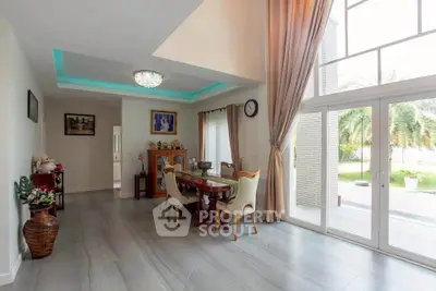 Spacious living room with elegant dining area and large windows overlooking lush garden.