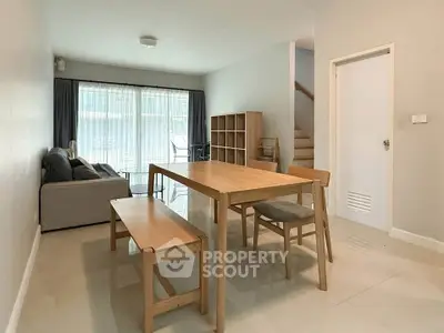Spacious living room with modern dining area and natural light