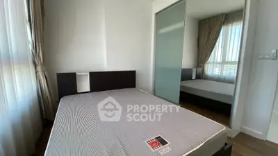 Modern bedroom with large window and mirrored closet in a stylish apartment.