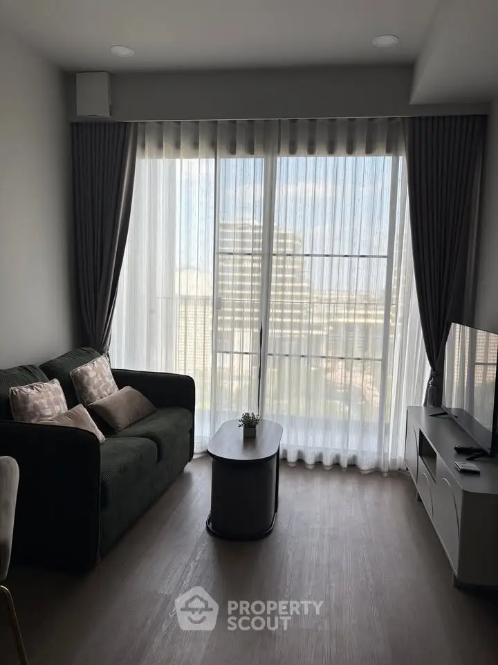 Modern living room with large window and stylish furniture, offering a bright and inviting atmosphere.