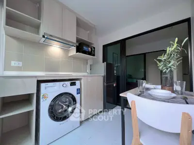 Modern kitchen with washing machine and dining area in stylish apartment