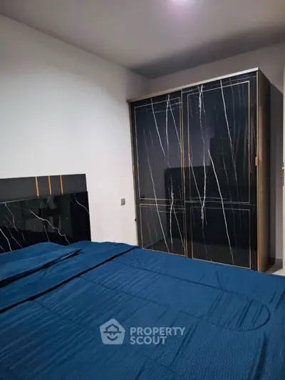 Modern bedroom with stylish black wardrobe and blue bedding
