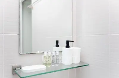 Modern bathroom with sleek glass shelf and stylish toiletries