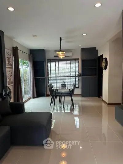 Modern living room with sleek furniture and large windows for natural light.