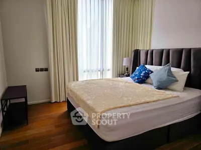 Cozy bedroom with elegant decor and natural light, featuring a plush bed and stylish furnishings.