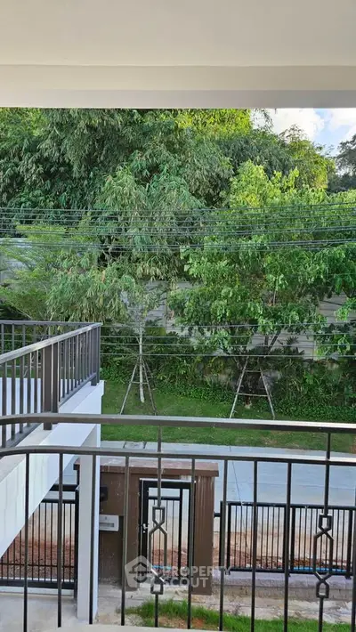 Charming balcony view with lush greenery and modern railing design.