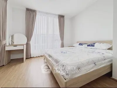 Spacious bedroom with natural light, modern furnishings, and elegant decor in a stylish apartment.
