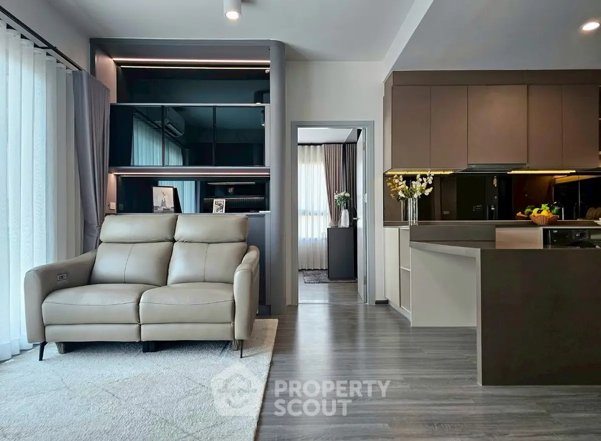 Modern open-layout living room with sleek kitchen and cozy seating area, perfect for urban living.