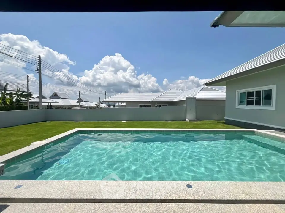 Stunning backyard pool with clear blue water and lush green lawn, perfect for relaxation and entertainment.