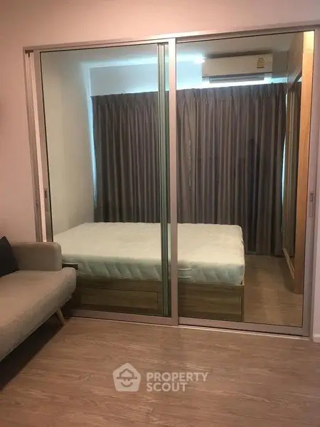 Modern bedroom with sliding glass doors and cozy furnishings in a stylish apartment.