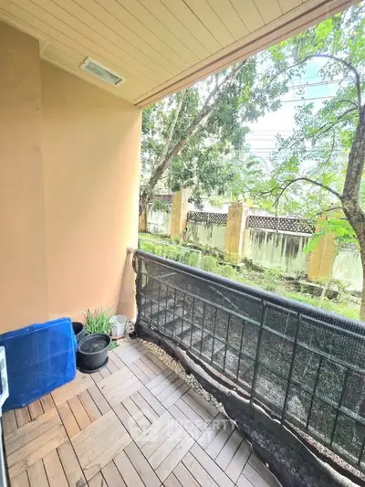 Charming balcony with wooden flooring and lush garden view, perfect for relaxation and outdoor enjoyment.