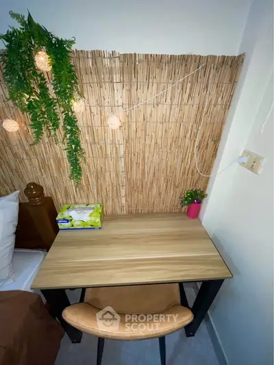 Cozy study nook with wooden desk, chair, and decorative lighting