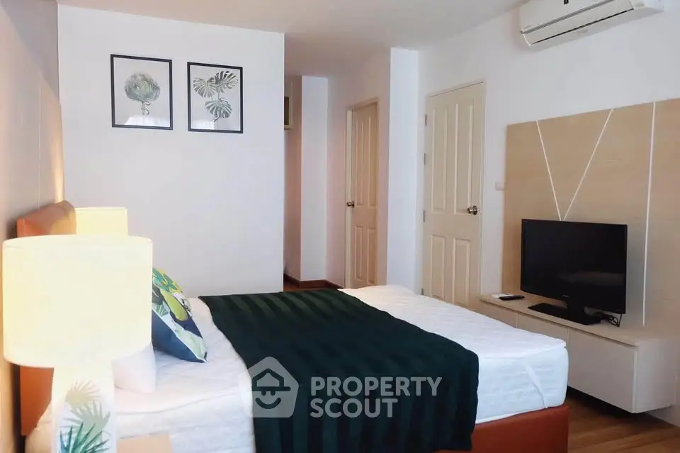 Modern bedroom with stylish decor and air conditioning in a cozy apartment.
