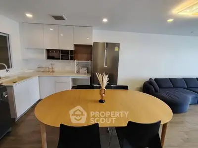 Modern open-plan kitchen and living room with sleek furniture and appliances.