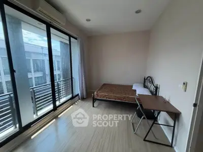 Spacious bedroom with balcony access and natural light in modern apartment.
