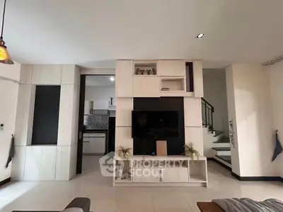 Modern living room with sleek TV unit and open kitchen layout