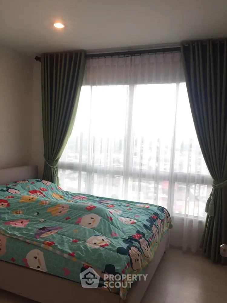 Cozy bedroom with large window and colorful bedding, offering ample natural light and a serene atmosphere.