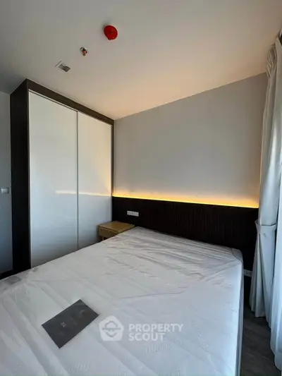 Modern bedroom with sleek design and ambient lighting, featuring a large wardrobe and cozy atmosphere.
