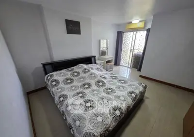 Spacious bedroom with modern decor and balcony access in a stylish apartment.