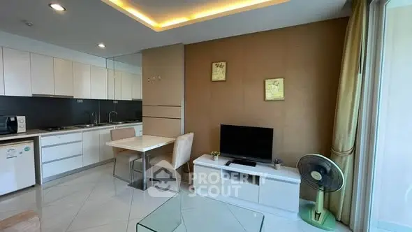 Modern open-layout kitchen and living area with sleek design and natural lighting.