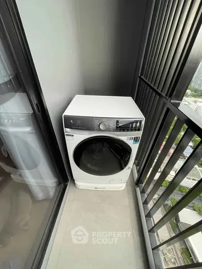 Modern washing machine on high-rise balcony with city view