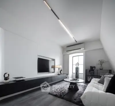 Sleek modern living room with minimalist design, featuring a wall-mounted TV, stylish furniture, and ambient lighting.