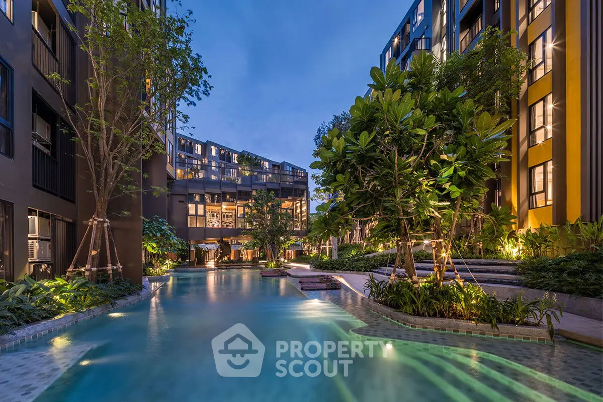 Luxurious residential complex with stunning pool and lush greenery at dusk.
