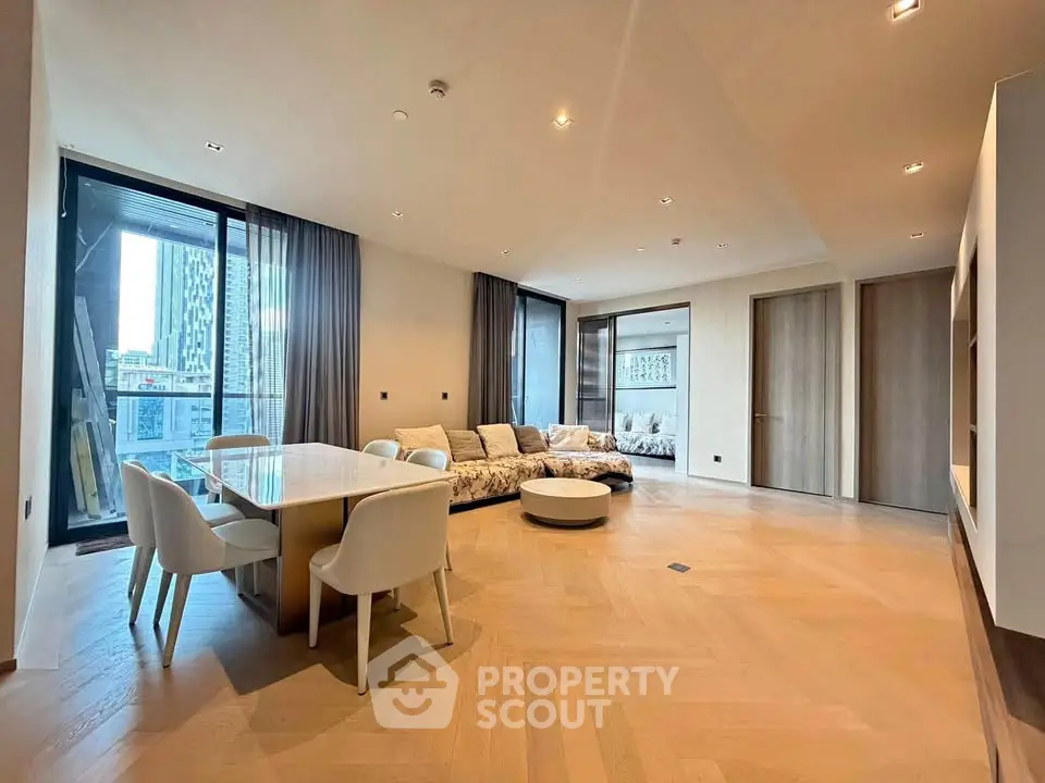 Spacious modern living room with elegant dining area and large windows offering city views.