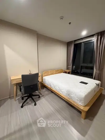 Modern bedroom with wooden furniture and large window offering city view