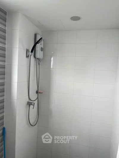 Modern bathroom with sleek shower and white tiled walls, perfect for a minimalist home design.