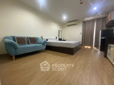 Spacious modern bedroom with cozy sofa and wooden flooring