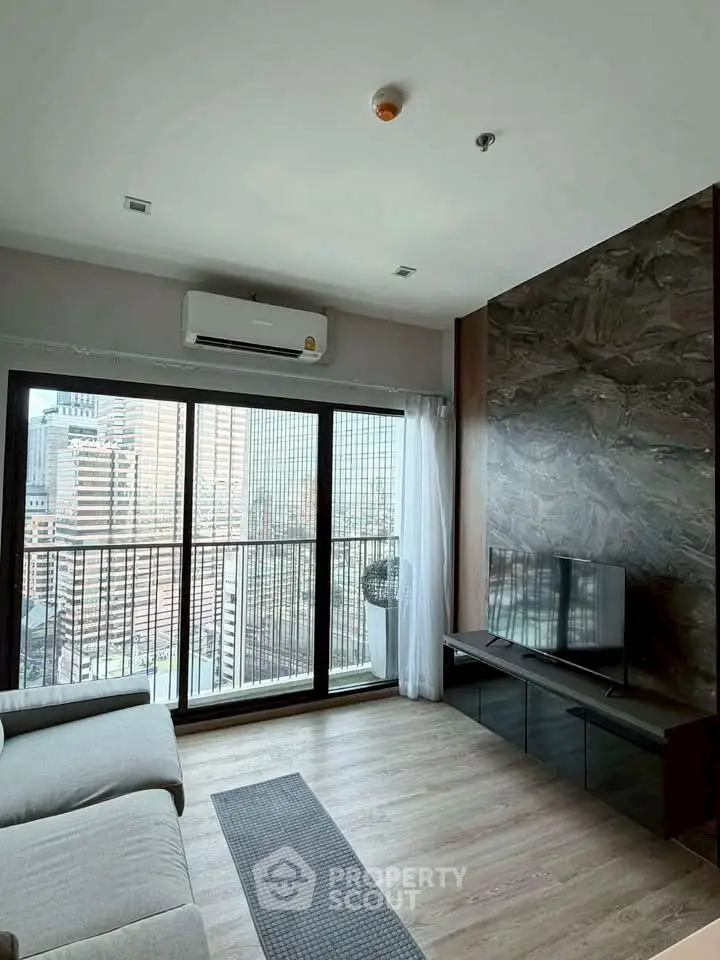 Modern living room with city view, sleek furniture, and large windows.