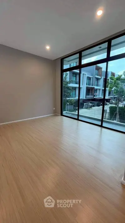 Spacious modern living room with large windows and wooden flooring