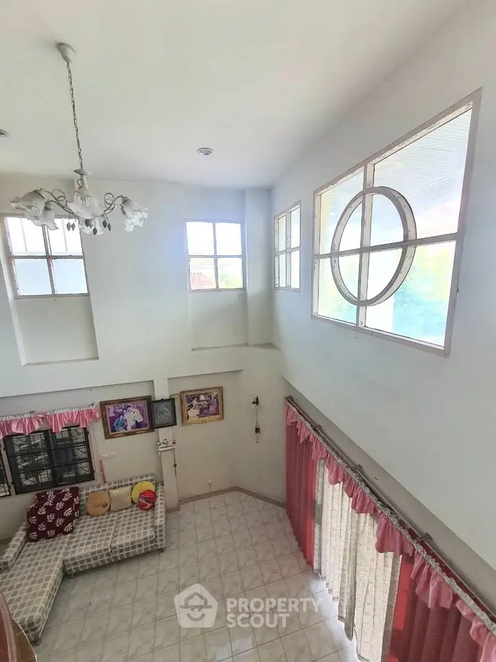 Spacious living room with high ceiling and large windows for natural light