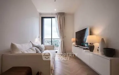 Modern living room with elegant decor and large window offering natural light and city view.
