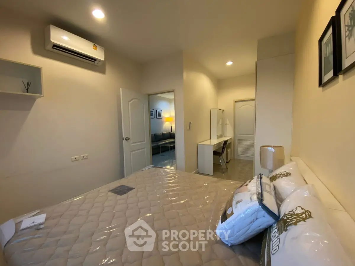 Spacious bedroom with modern decor and air conditioning in a cozy apartment.