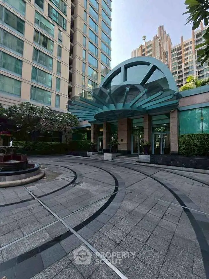 Stunning modern building entrance with elegant architectural design and lush landscaping.