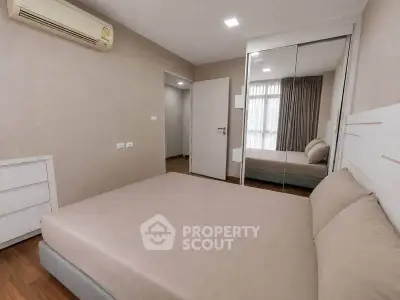 Modern bedroom with mirrored closet and air conditioning in a stylish apartment.