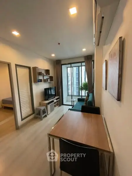 Modern living room with balcony view, stylish furniture, and ample natural light.