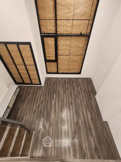 Modern loft with wooden flooring and large windows, perfect for urban living.