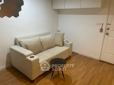Cozy living room with modern sofa and small coffee table on wooden flooring.